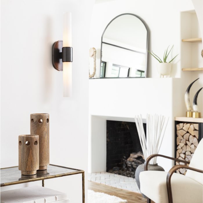 Mantle with black framed mirror and a white linen chair