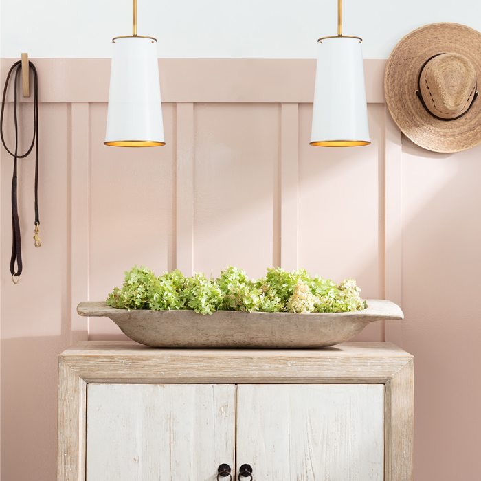 Entryway console with a bowl of greenery and two white and gold pendants