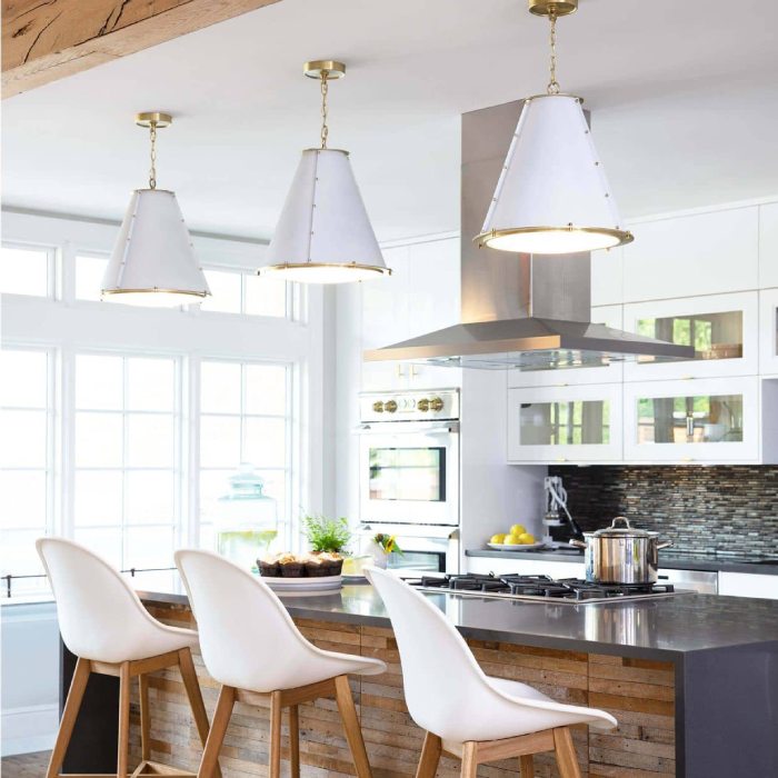 Kitchen with a black waterfall countertop, white chairs and white ceiling pendants