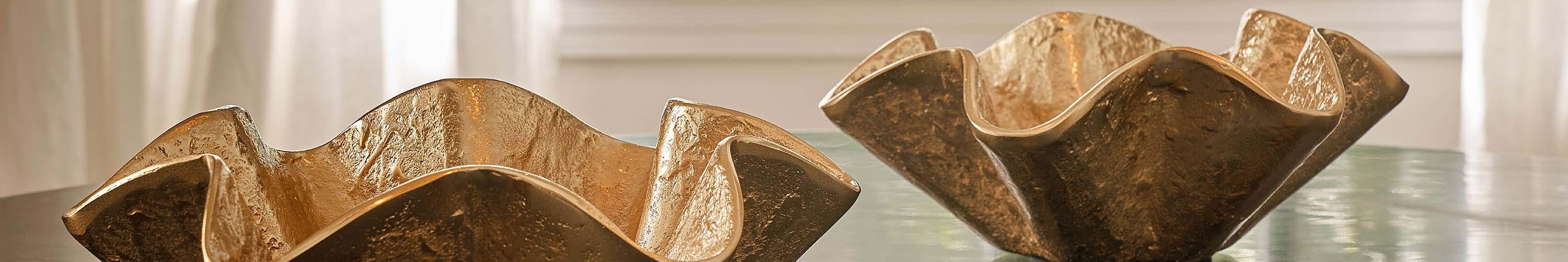 Two brass ruffle bowls on a table