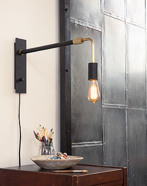 Light fixure with an edison style bulb over a wooden side table