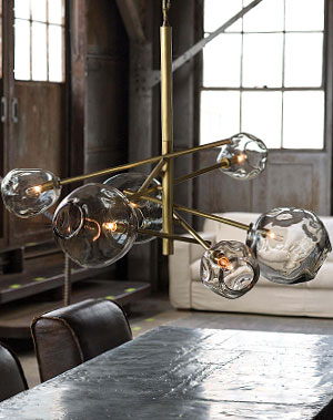 Molten bulb natural brass chandelier above a table