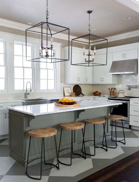 Southern styled kitchen with large black ceiling chandeliers, wooden chairs and a green painted island