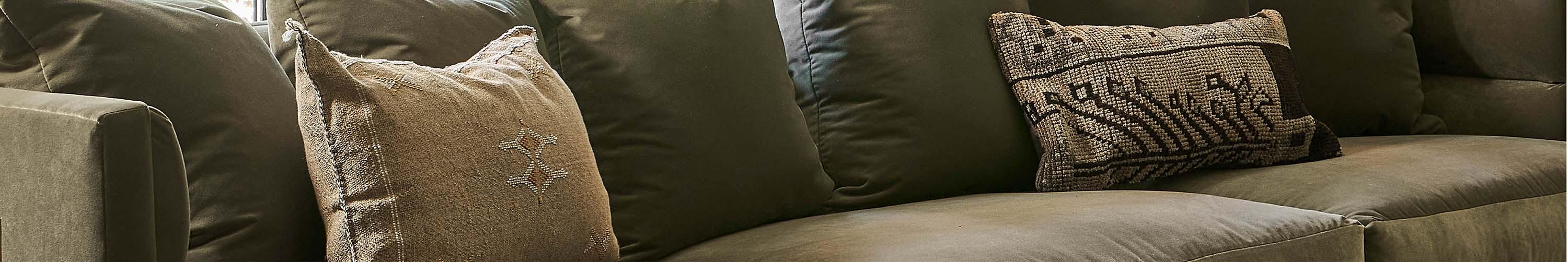 Green sectional sofa in front of a window