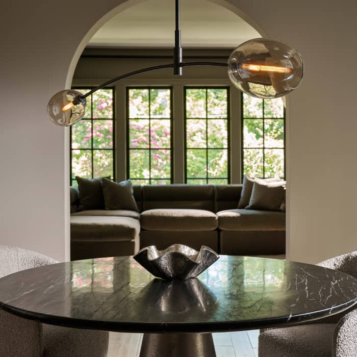 Breakfast nook with a black ceiling light, a wooden table, and white drapes