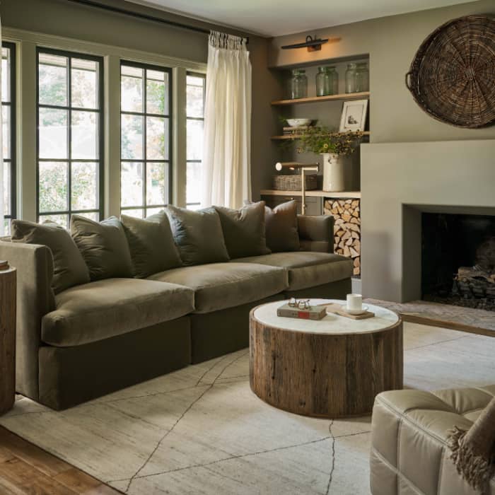 Living room with a white wool carpet, black glass coffee table, white chairs, and a white couch