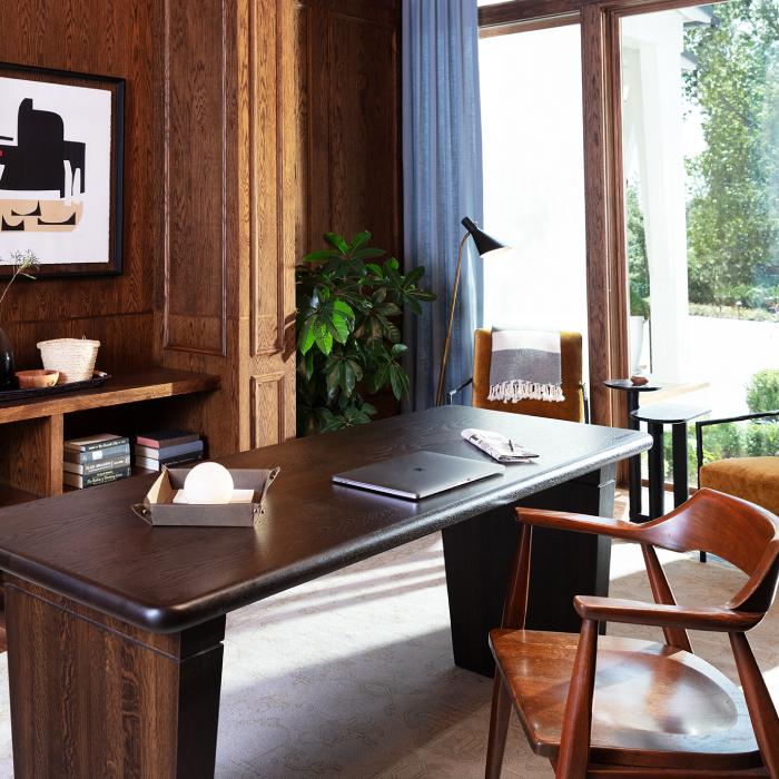 Mantle with black framed mirror and a white linen chair