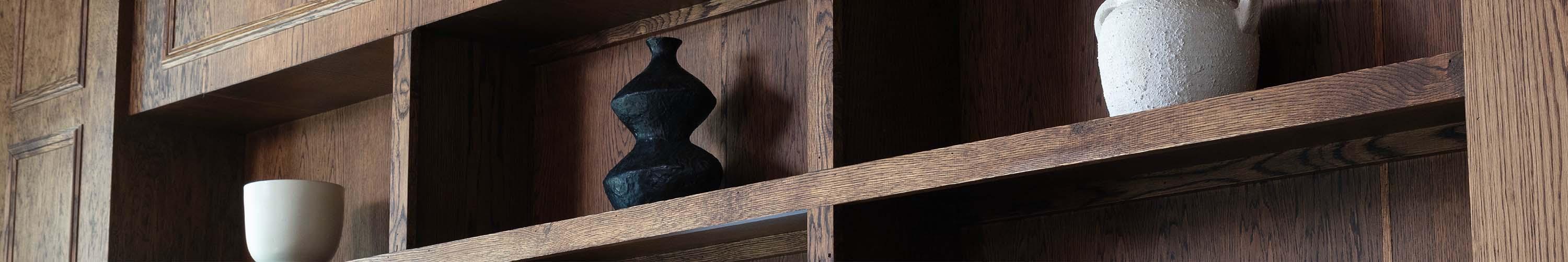Wooden shelf with black decorative vase