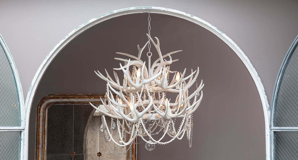 Large entryway with a southern styled antler and bead white chandelier