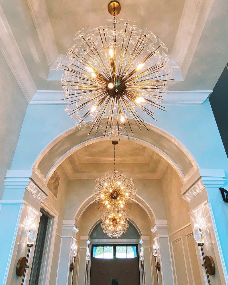 Well lit modern entryway with modern sputnik-styled orb chandelier with natural brass finishing