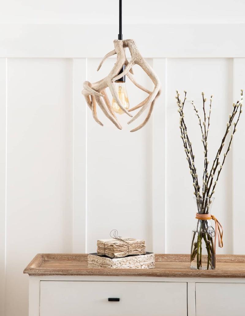 Natural Oak console with plants, and paper on top, with a southern styled antler chandelier above them