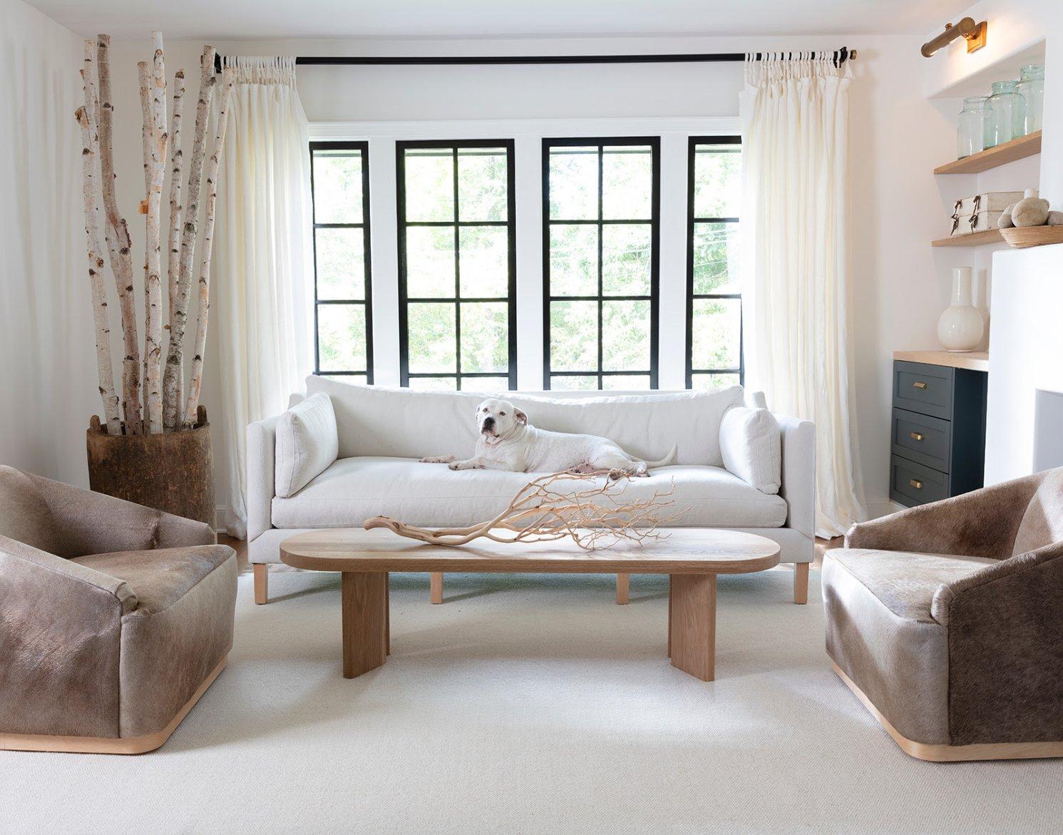 Modern living room with new oak coffee table, brown swivel chairs and a white couch