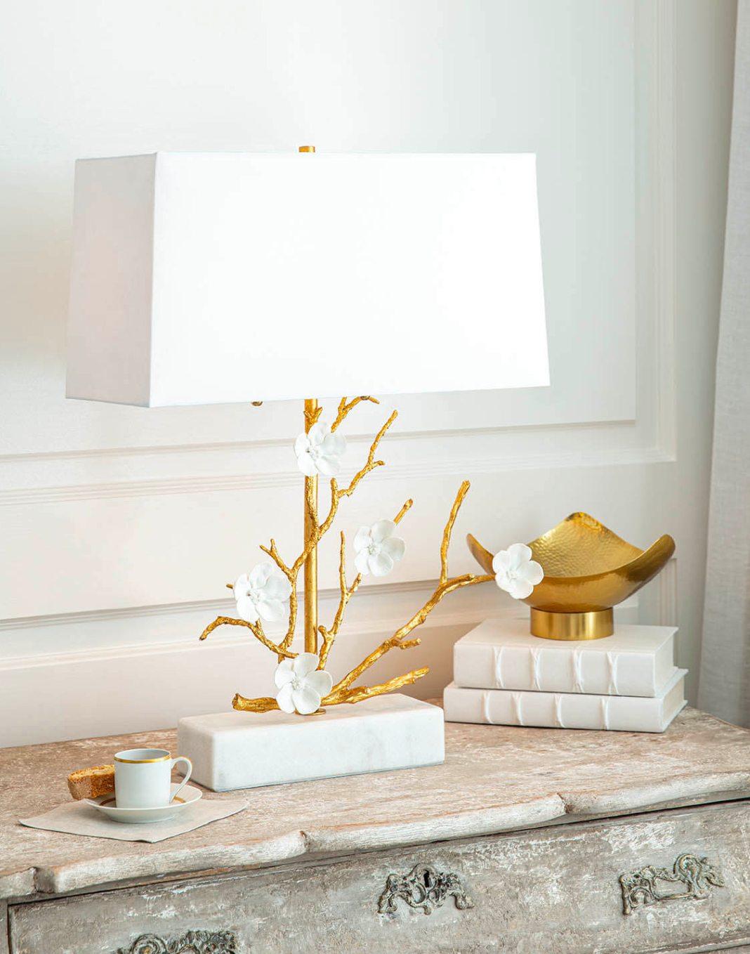 Arts & Crafts styled side table with a small espresso cup, a gold branched table lamp with a white shade, and a golden bowl