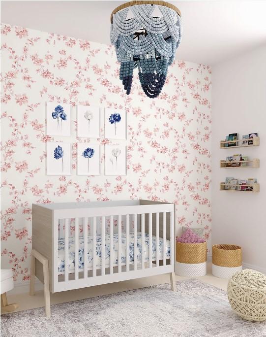 Pink infants bedroom, with a white crib, and a blue wood beaded chandelier