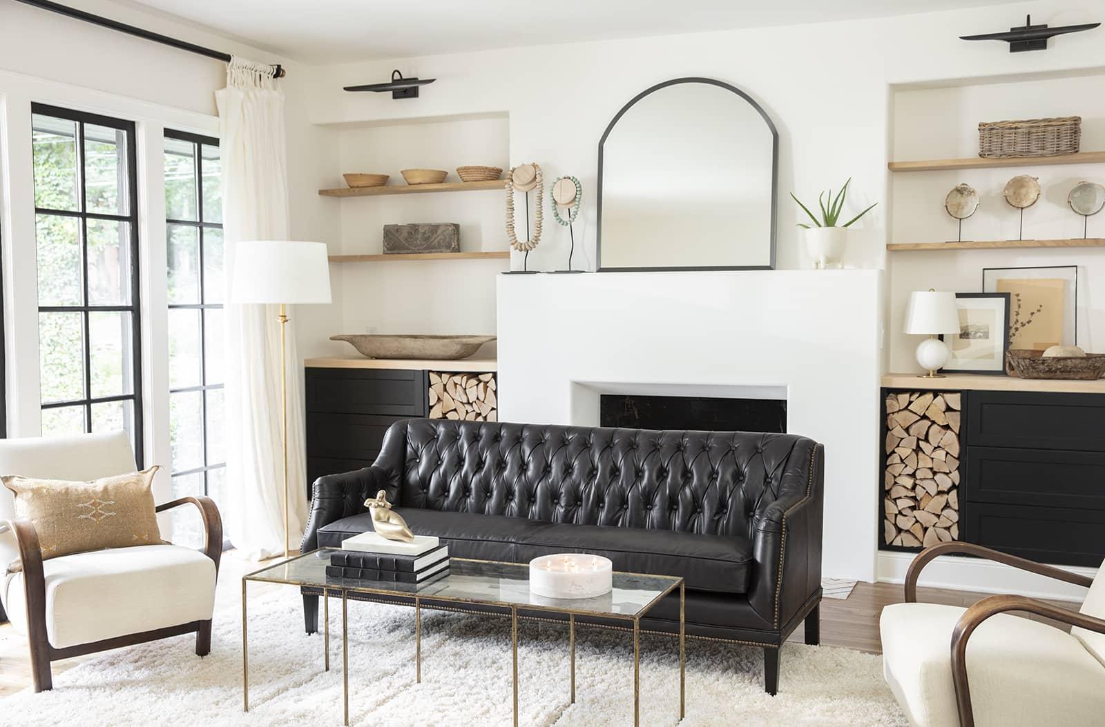 Rustic living room with a fireplace, sconces and a black leather couch