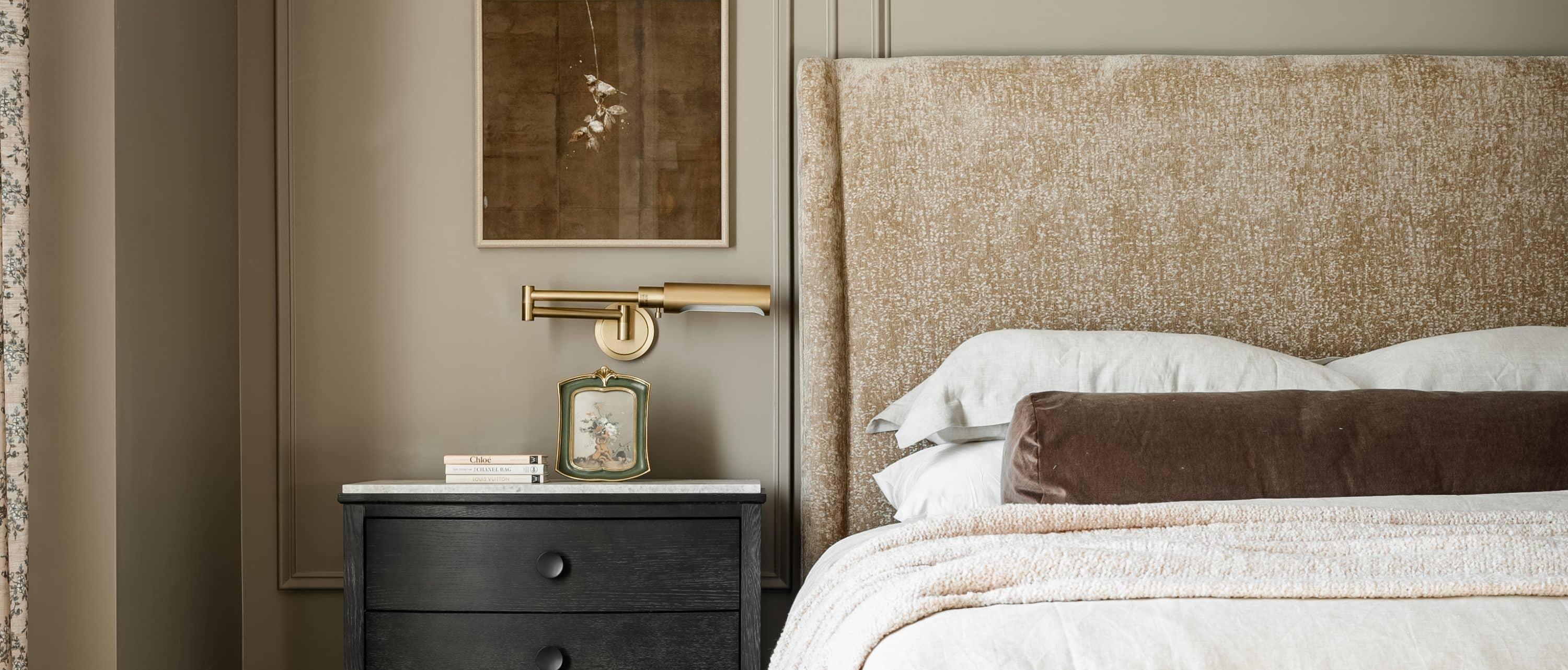 brass picture light beside a bed