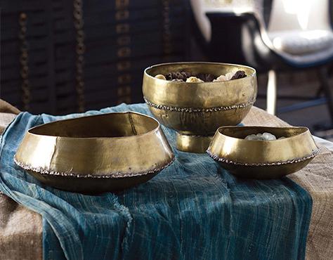 Three natural brass So-Cal style bowls sitting on a handmade piece of Mali cloth 