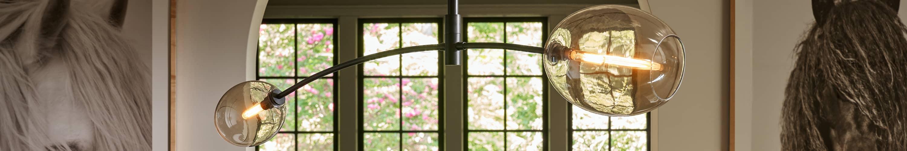Two arm pendant light in front of four windows