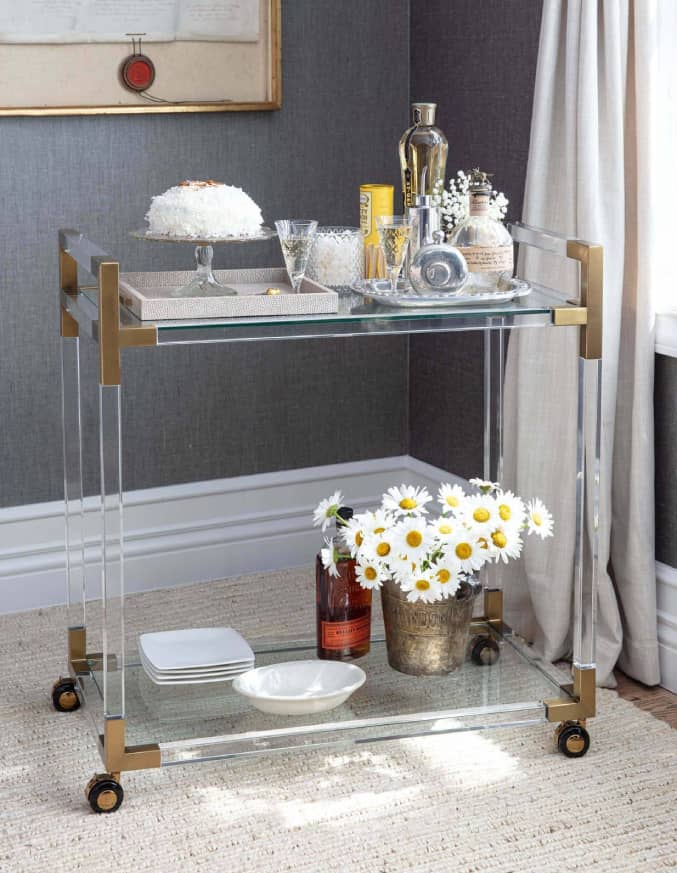 epoxy bar cart with natural brass accents in a corner with glasses on top