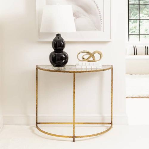 half circle gold table with a black lamp on top