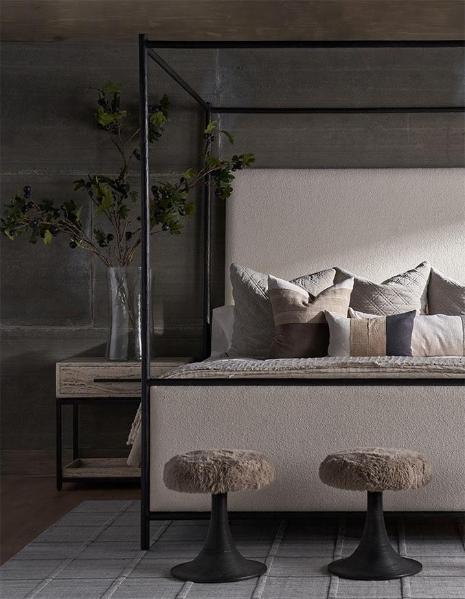 black bed frame with a wooden nightstand with a vase on top
