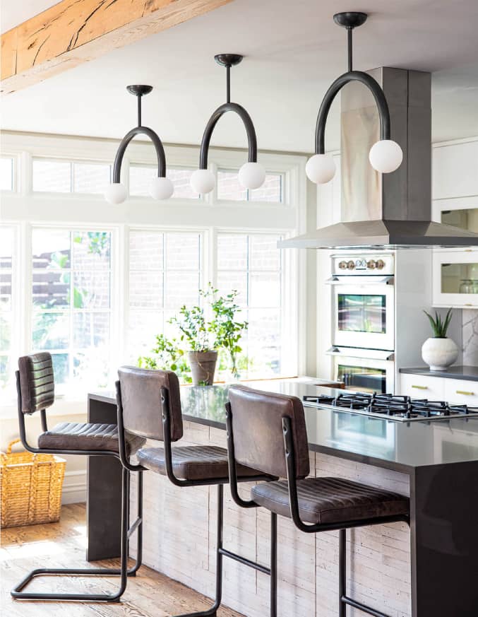 three leather bar chairs next to a kitchen island