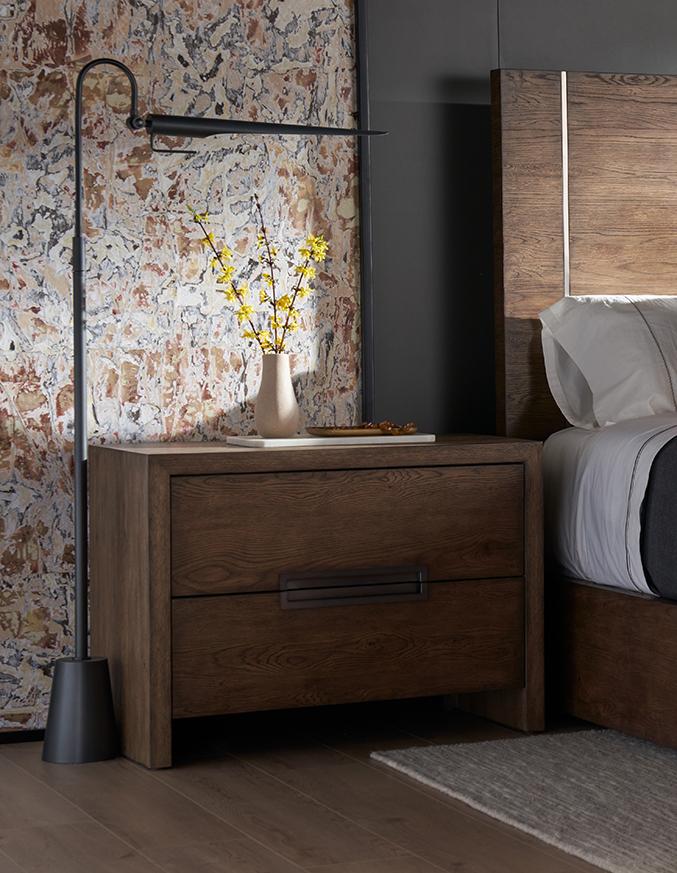 dark wood nightstand with a picture and a black floor lamp