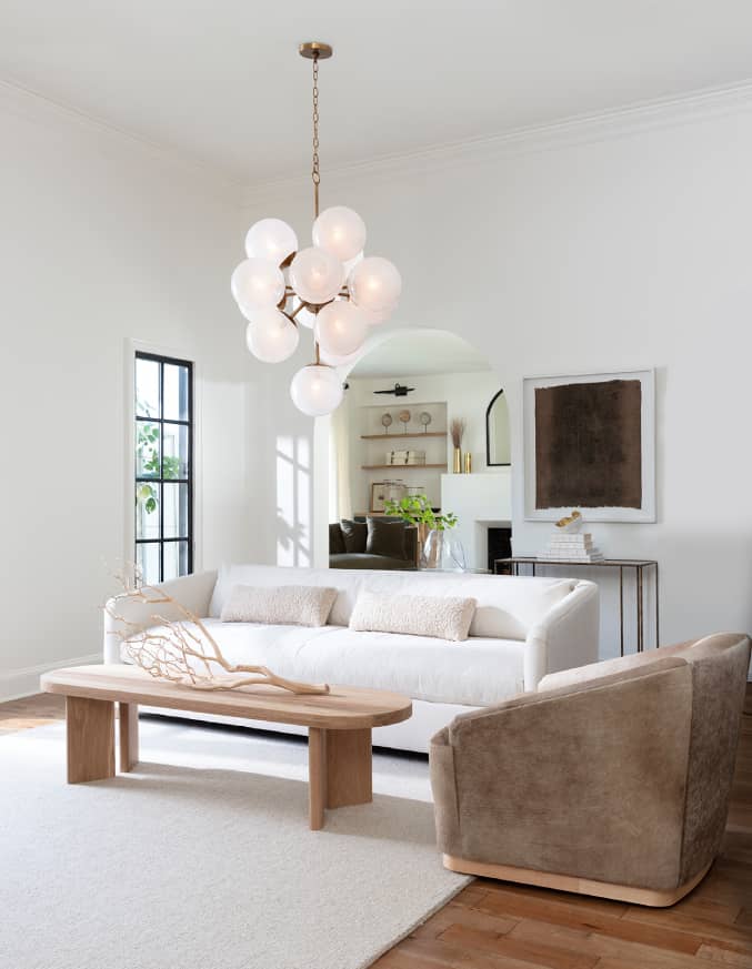 brown swivel chair next to wooden rectangular coffee table and white two seat sofa