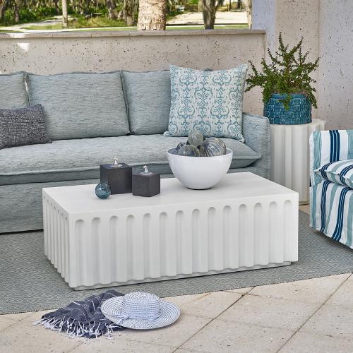 concrete outdoor coffee table surrounded by a blue sofa and chair