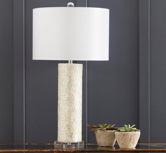 Table lamp next to two small stone bowls