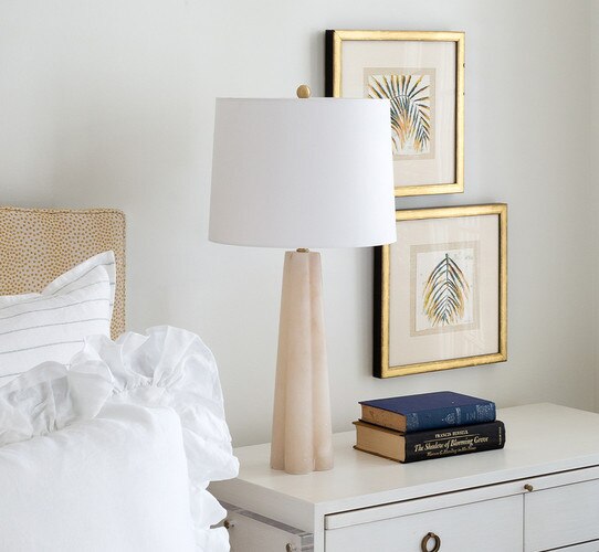 Large alabaster lamp on white bedside table