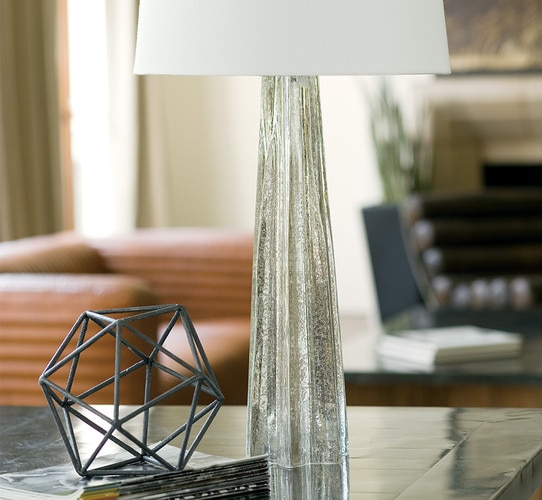 Antique mercury table lamp on a metal side table next to a metal art piece
