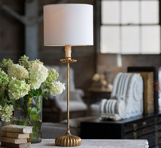 Antique gold leaf table lamp next to a vase of hydrangeas