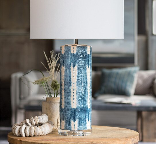 Ceramic white and blue textured table lamp next to a small vase