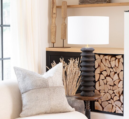 Tall black wooden table lamp on a small side table