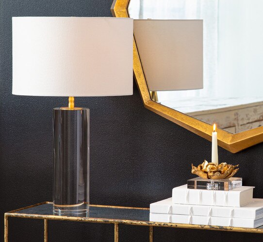 Solid cylindrical crystal table lamp on a zinc console table