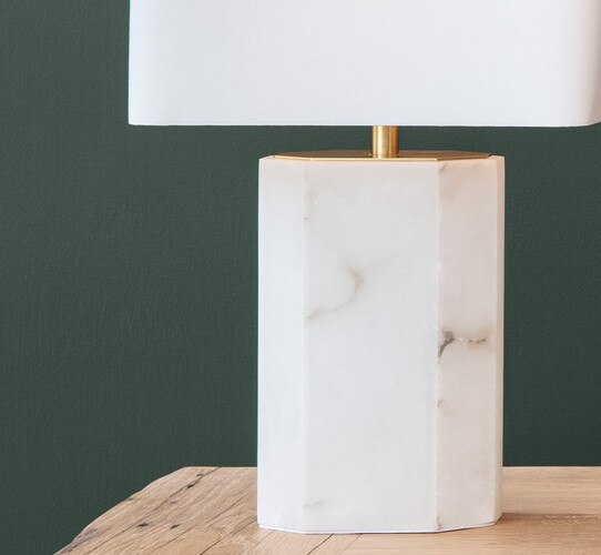 Hexagonal alabaster table lamp on a raw wooden table