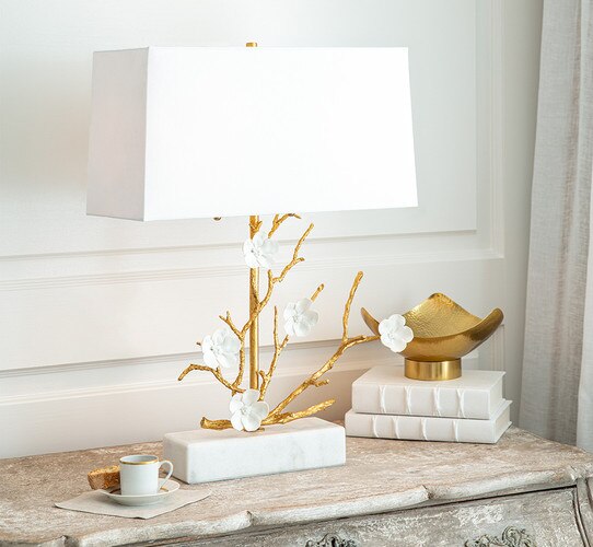 Gold table lamp with sculpted branches and white ceramic flowers