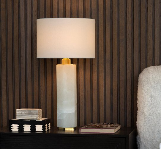 Tall alabaster table lamp on a nightstand