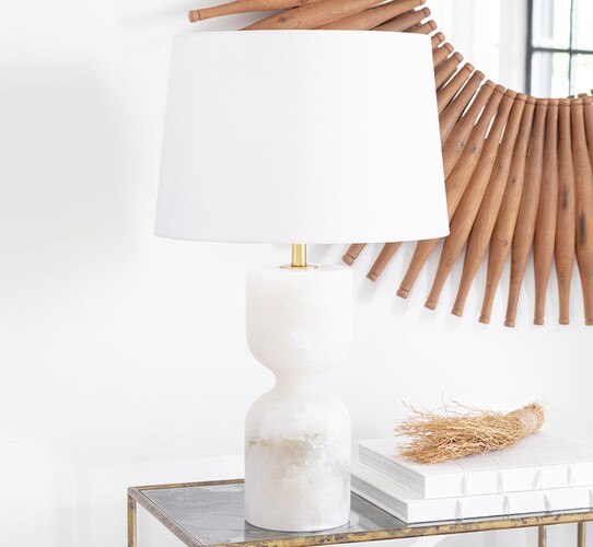 Alabaster table lamp with hourglass base on a console table