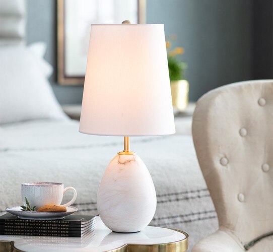 Smooth alabaster mini lamp next to an accent chair