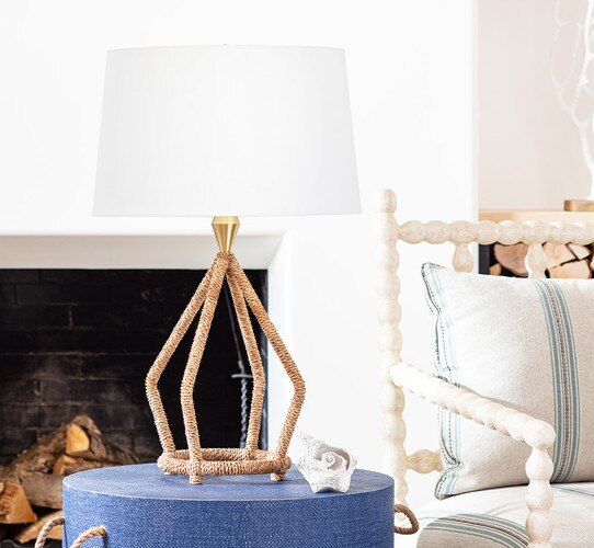 Open frame table lamp made of wicker on a blue side table