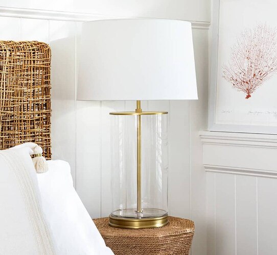 Glass and brass table lamp on a rattan nightstand