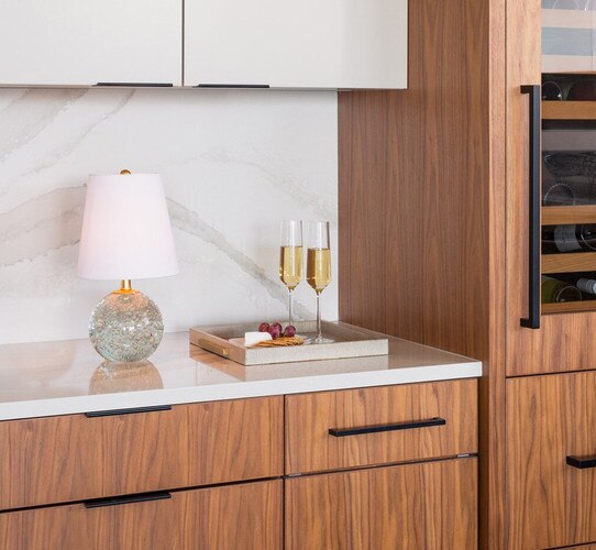 Crystal bubble lamp on a kitchen counter next to a decorative tray with glasses of champagne