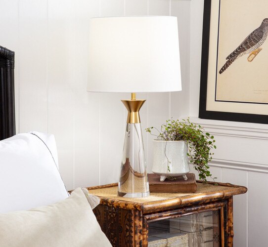Crystal lamp with gold top on a wooden bedside table