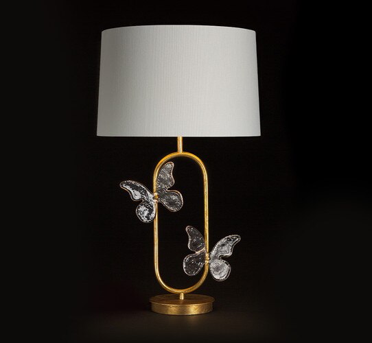 Gold table lamp with glass butterflies and a white linen shade