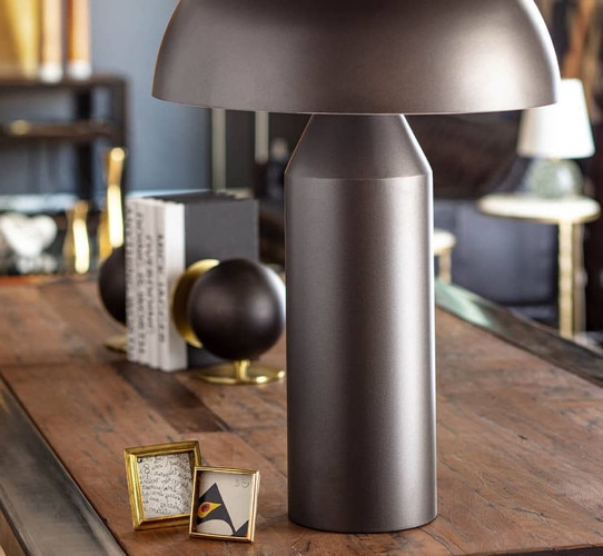 Black metal table lamp on a wood console table