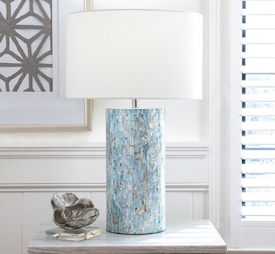 Blue multicolored bone lamp next to a cast silver magnolia on a marble side table