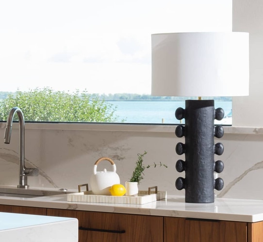 Black metal table lamp on white kitchen counter beside a tray