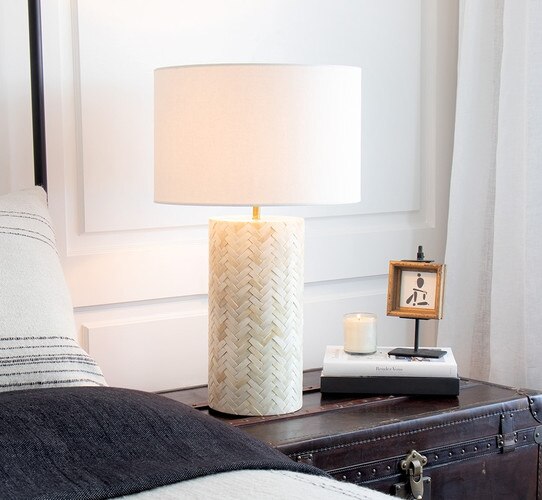 Bone table lamp with a criss-cross design on a bedside chest